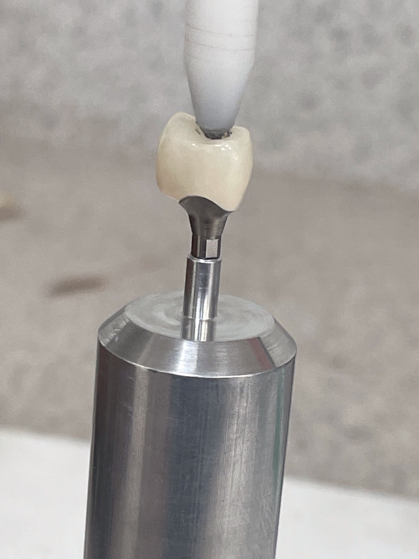 QUICR implant cementer seating a crown on an abutment
